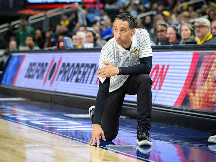 Marquette coach Shaka Smart kneels on the sideline